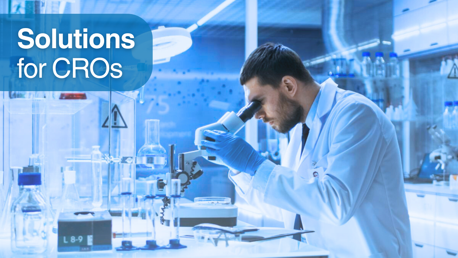 A medical researcher analyzes a sample through a microscope in a laboratory setting. At the top left, a text that reads Solutions for CROs.