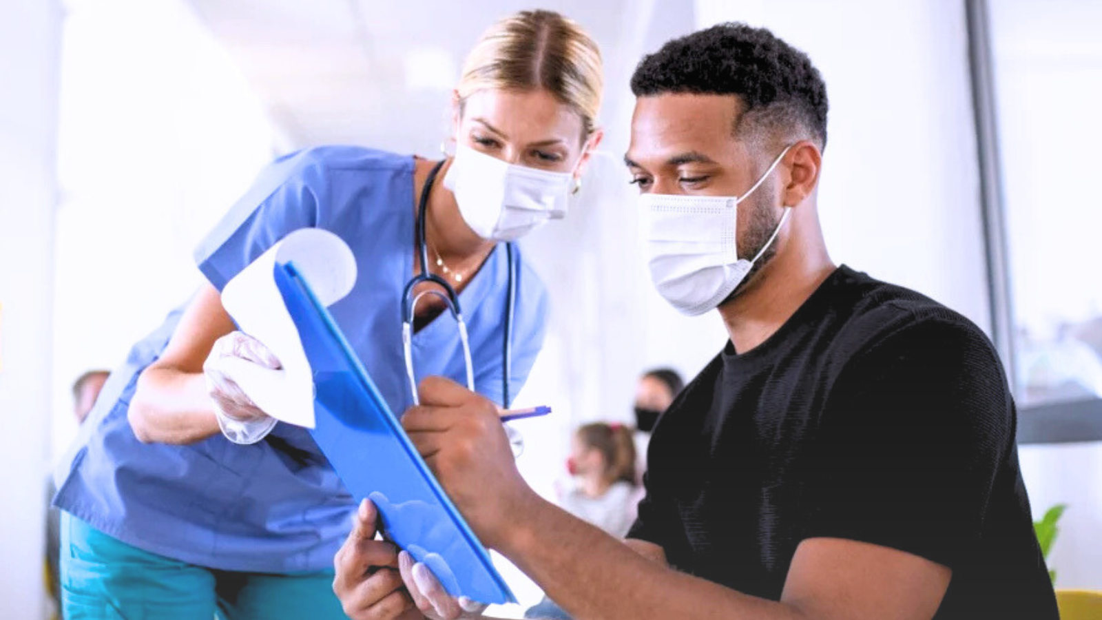A nurse and a doctor collaborate on a patient care task in a clinical setting.